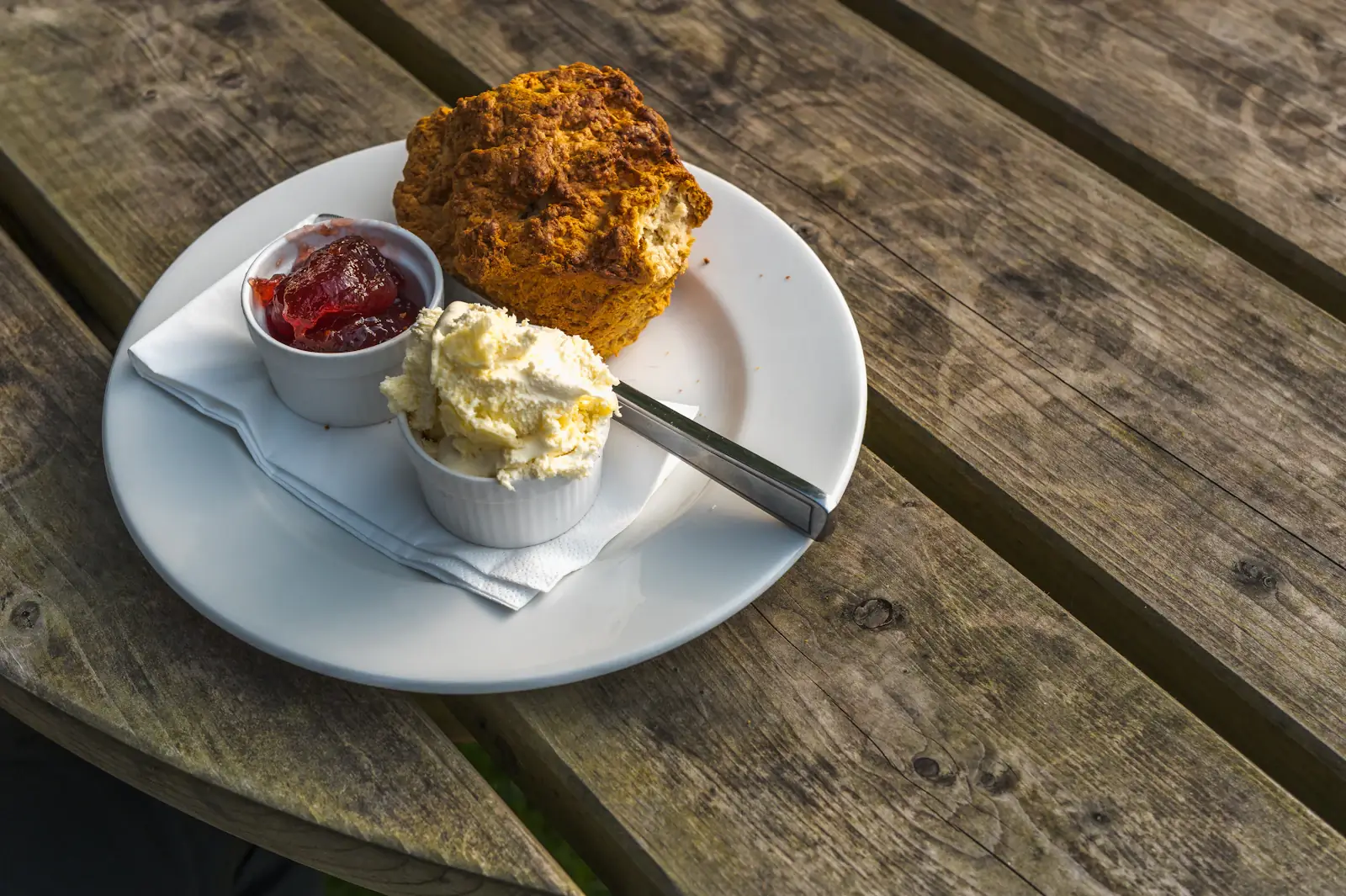 A scone with clotted cream and strawberry jam